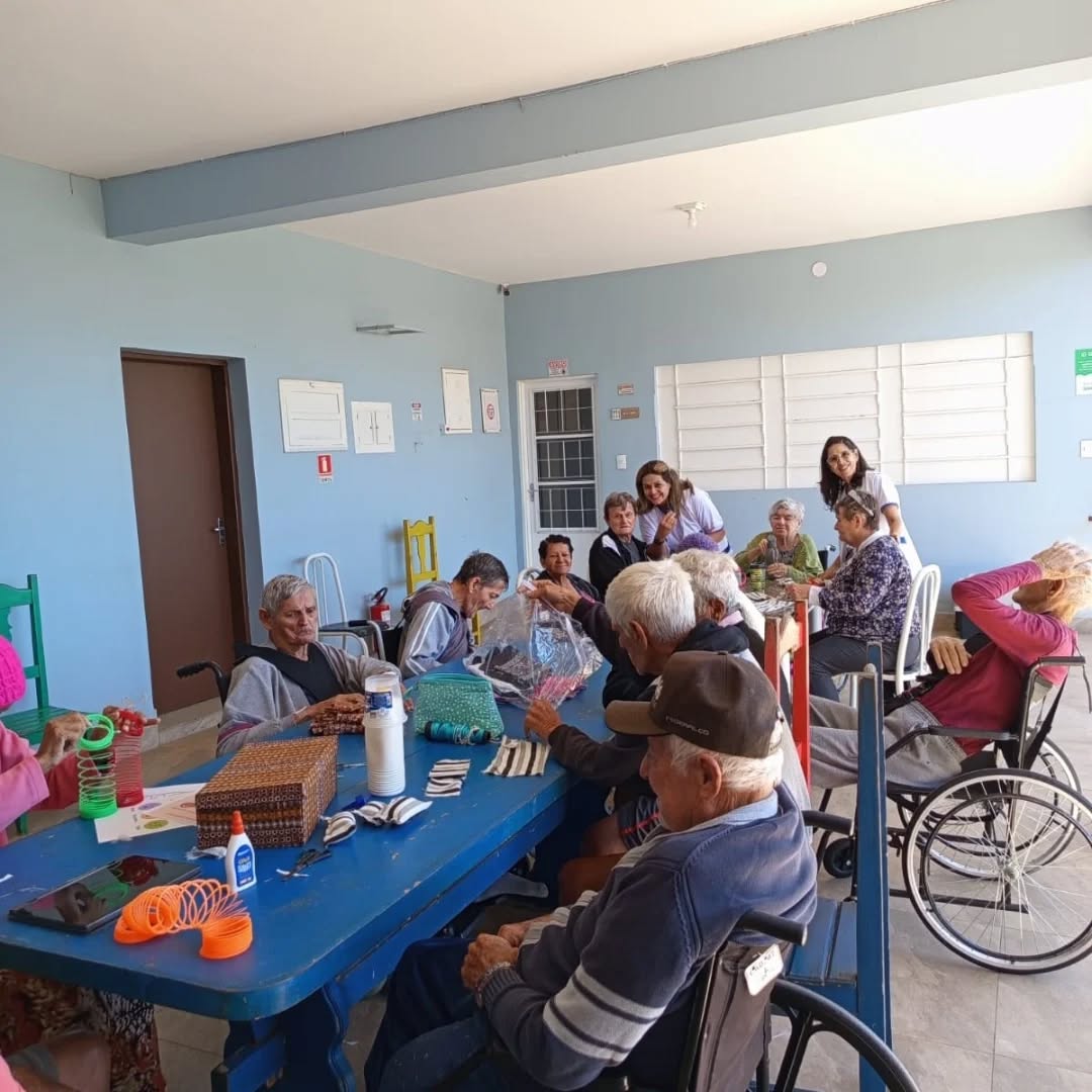 Pode ser uma imagem de uma ou mais pessoas, pessoas estudando, pessoas sorrindo e mesa